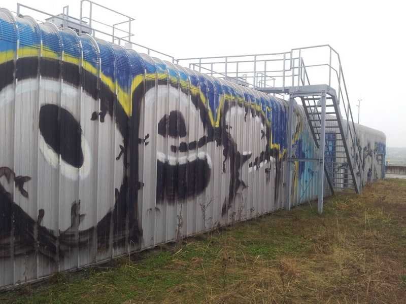 Ein Sprayer Mauer. TÜV-geprüfte Graffitientfernung